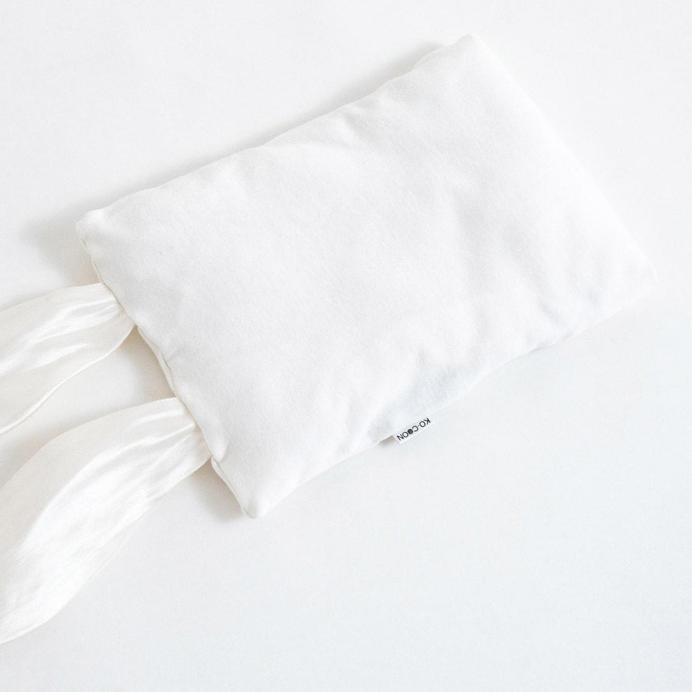 A white sensory bunny pillowcase made of cotton knit with pure silk ears. Inner pillow is made of merino wool, designed as a baby cuddle toy and pillow.